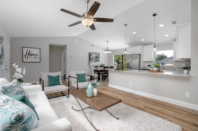 3117 Pine Tree Dr, Edgewater, FL 32141 - living room featuring light wood-type flooring, vaulted ceiling, ceiling fan, recessed lighting, and a chandelier