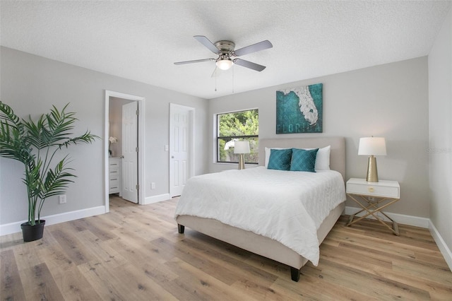 3117 Pine Tree Dr, Edgewater, FL 32141 - bedroom with light wood finished floors, ceiling fan, a textured ceiling, and ensuite bathroom