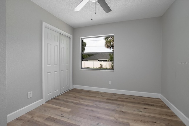 3117 Pine Tree Dr, Edgewater, FL 32141 - unfurnished bedroom featuring wood finished floors, a textured ceiling, a closet, and ceiling fan