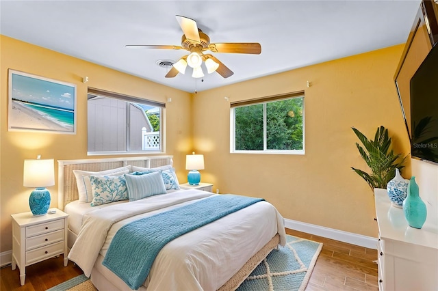 10 Venetian Cir, Port Orange, FL 32127 - bedroom with multiple windows, wood finished floors, and ceiling fan