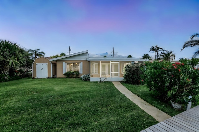 10 Venetian Cir, Port Orange, FL 32127 - back of property with a storage unit, a lawn, and a sunroom