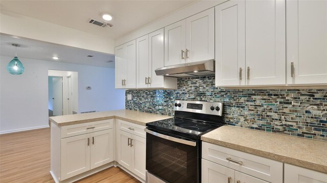 1017 Chippewa Trl, Daytona Beach, FL 32117 - kitchen featuring stainless steel range with electric stovetop, under cabinet range hood, a peninsula, light countertops, and white cabinets