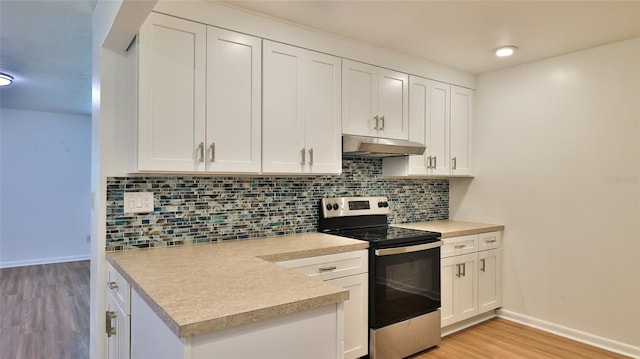1017 Chippewa Trl, Daytona Beach, FL 32117 - kitchen featuring stainless steel range with electric cooktop, under cabinet range hood, light countertops, and white cabinets