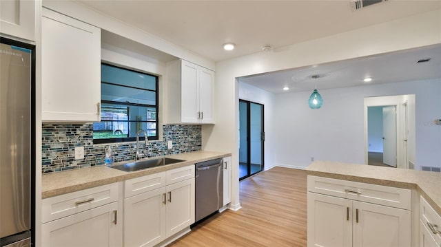 1017 Chippewa Trl, Daytona Beach, FL 32117 - kitchen with stainless steel appliances, light countertops, decorative backsplash, white cabinetry, and recessed lighting