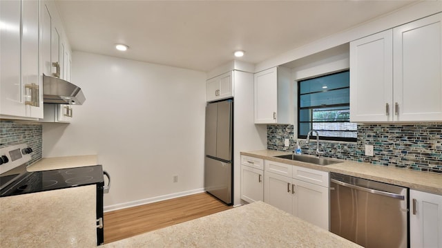 1017 Chippewa Trl, Daytona Beach, FL 32117 - kitchen with appliances with stainless steel finishes, under cabinet range hood, light wood-type flooring, white cabinetry, and tasteful backsplash