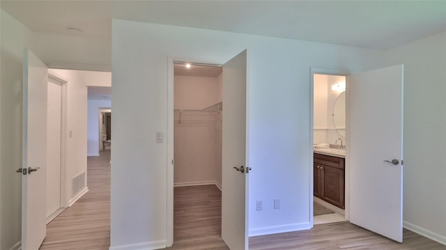 1017 Chippewa Trl, Daytona Beach, FL 32117 - unfurnished bedroom featuring light wood-style floors, a spacious closet, a closet, and ensuite bathroom
