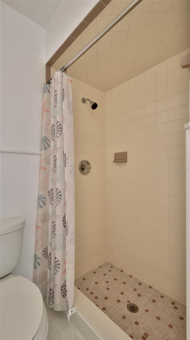 1017 Chippewa Trl, Daytona Beach, FL 32117 - full bathroom featuring a shower stall, tile patterned floors, and wainscoting