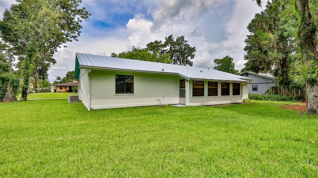 1017 Chippewa Trl, Daytona Beach, FL 32117 - rear view of house with a metal roof, a lawn, and a sunroom