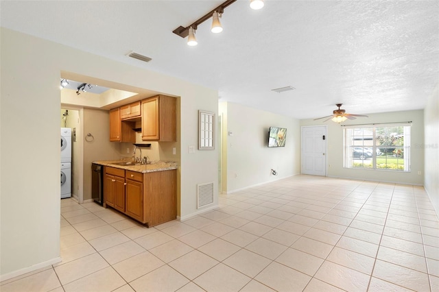 511 Polaris Loop Unit 105, Casselberry, FL 32707 - kitchen with light countertops, a ceiling fan, light tile patterned flooring, stacked washer / drying machine, and black dishwasher