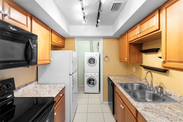 511 Polaris Loop Unit 105, Casselberry, FL 32707 - kitchen with black appliances, light tile patterned floors, light countertops, and stacked washer / drying machine