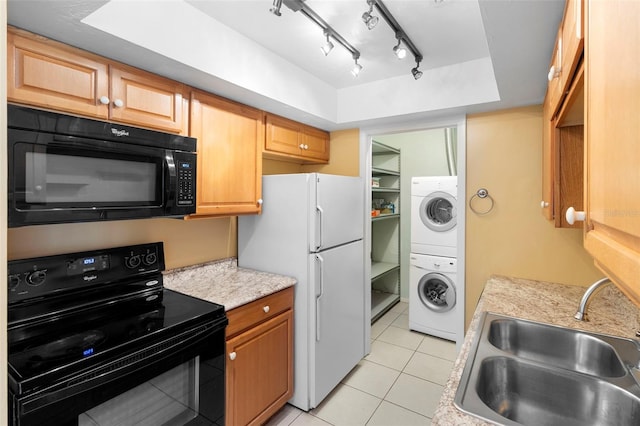 511 Polaris Loop Unit 105, Casselberry, FL 32707 - kitchen with black appliances, estacked washer and dryer, light countertops, light tile patterned floors, and a raised ceiling