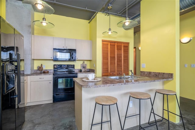 208 Wall St Unit 204, Daytona Beach, FL 32114 - kitchen with black appliances, finished concrete floors, a high ceiling, a peninsula, and a breakfast bar