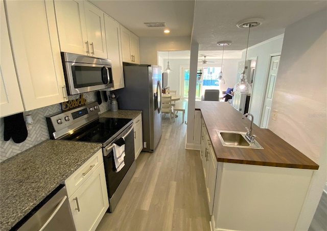 4786 S Atlantic Ave Unit 3, Ponce Inlet, FL 32127 - kitchen with wood counters, appliances with stainless steel finishes, light wood finished floors, white cabinetry, and recessed lighting