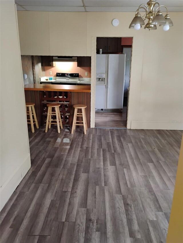 615 Weber Ave, Daytona Beach, FL 32114 - kitchen with white refrigerator with ice dispenser, electric stove, extractor fan, dark wood-type flooring, and a chandelier