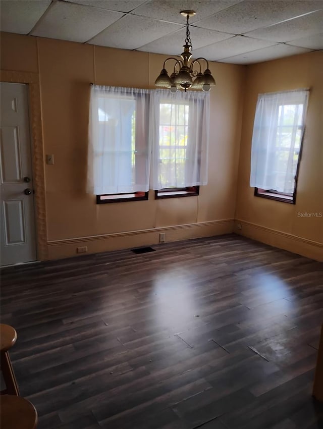615 Weber Ave, Daytona Beach, FL 32114 - unfurnished dining area with healthy amount of natural light, a chandelier, wood finished floors, and a drop ceiling