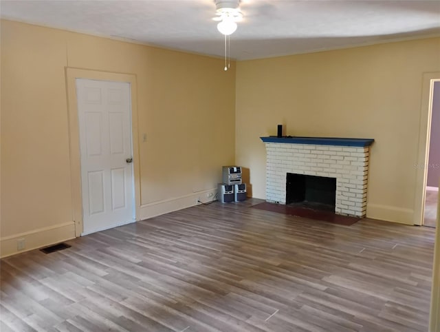 615 Weber Ave, Daytona Beach, FL 32114 - unfurnished living room featuring a ceiling fan, wood finished floors, and a brick fireplace
