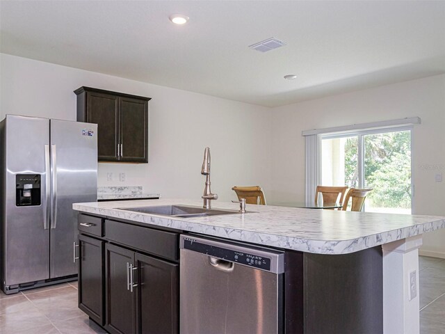 1915 Ganyard Ave SW, Palm Bay, FL 32908 - kitchen with stainless steel appliances, light countertops, an island with sink, light tile patterned floors, and recessed lighting