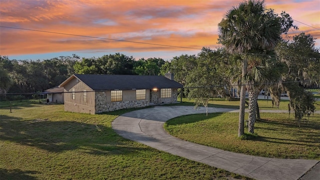 5759 Dogwood Rd, Port Orange, FL 32127 - view of front facade featuring stone siding, curved driveway, a front lawn, and a chimney