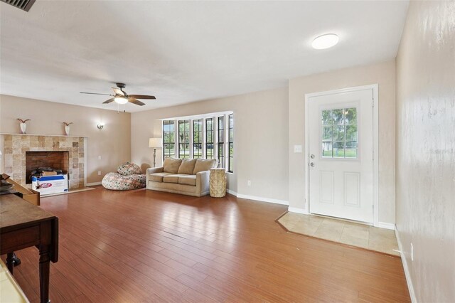 5759 Dogwood Rd, Port Orange, FL 32127 - living area with healthy amount of natural light, ceiling fan, light wood finished floors, and a fireplace with flush hearth