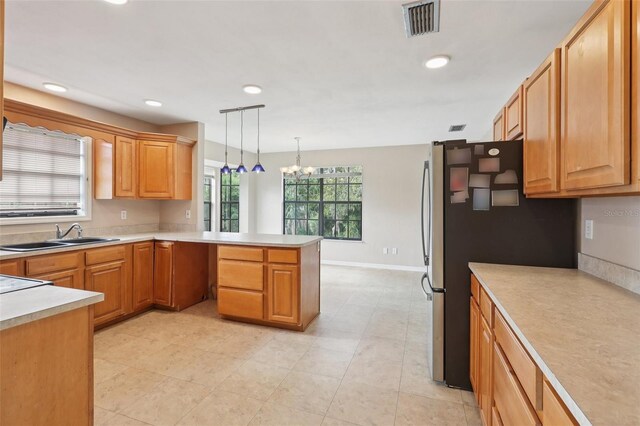 5759 Dogwood Rd, Port Orange, FL 32127 - kitchen with a peninsula, a chandelier, freestanding refrigerator, decorative light fixtures, and light countertops