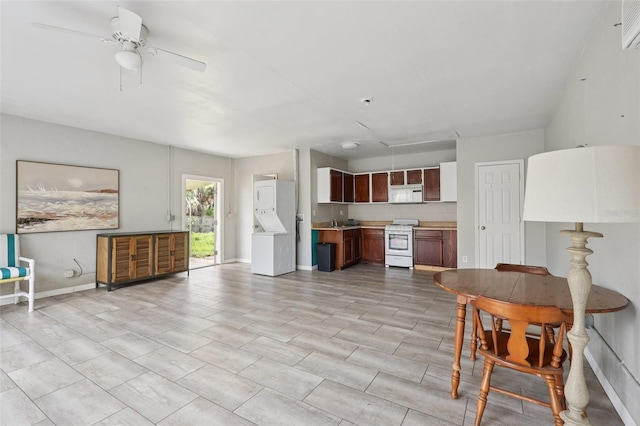 5759 Dogwood Rd, Port Orange, FL 32127 - kitchen with white range oven, stacked washer / dryer, light countertops, a ceiling fan, and open floor plan