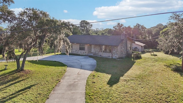 5759 Dogwood Rd, Port Orange, FL 32127 - view of front of property with a front lawn, stone siding, a chimney, and curved driveway