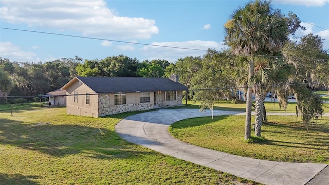 5759 Dogwood Rd, Port Orange, FL 32127 - view of front of home featuring curved driveway, stone siding, and a chimney