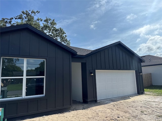 822 W 24th St, Sanford, FL 32771 - view of front of house featuring board and batten siding, roof with shingles, and a garage