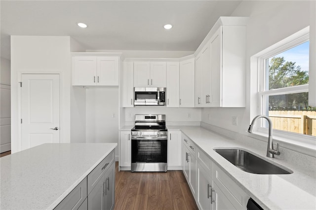 822 W 24th St, Sanford, FL 32771 - kitchen featuring stainless steel appliances, light stone counters, white cabinets, recessed lighting, and dark wood-style flooring