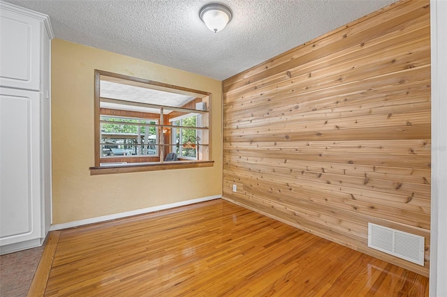 1085 Indigo Rd, Ormond Beach, FL 32174 - spare room featuring a textured ceiling, wood finished floors, and wood walls