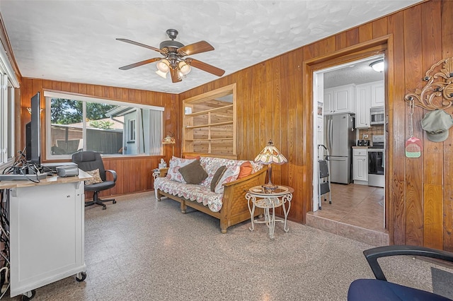 1085 Indigo Rd, Ormond Beach, FL 32174 - home office with wooden walls, a ceiling fan, a textured ceiling, and light flooring