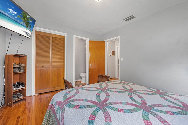 1085 Indigo Rd, Ormond Beach, FL 32174 - bedroom with a closet, wood finished floors, and ensuite bathroom