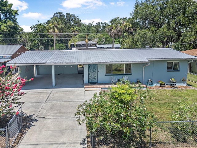 1085 Indigo Rd, Ormond Beach, FL 32174 - view of front of property featuring an attached carport, a metal roof, driveway, stucco siding, and view of wooded area