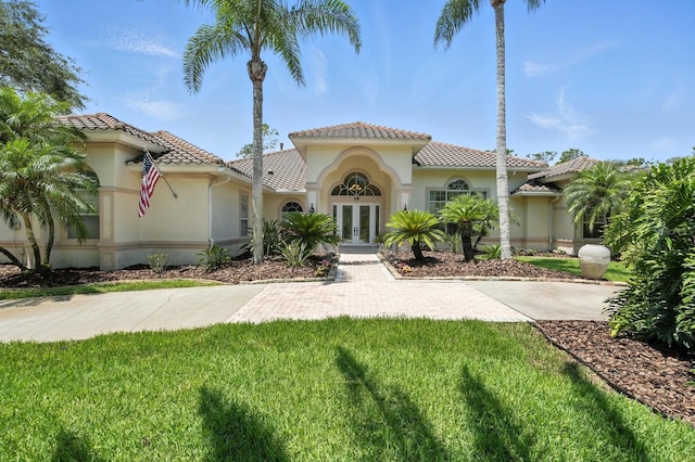 19 Tomoka Cove Way, Ormond Beach, FL 32174 - mediterranean / spanish-style home featuring french doors, a tile roof, stucco siding, and a front yard