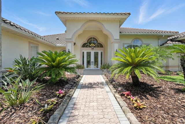 19 Tomoka Cove Way, Ormond Beach, FL 32174 - doorway to property with french doors, stucco siding, and a tile roof