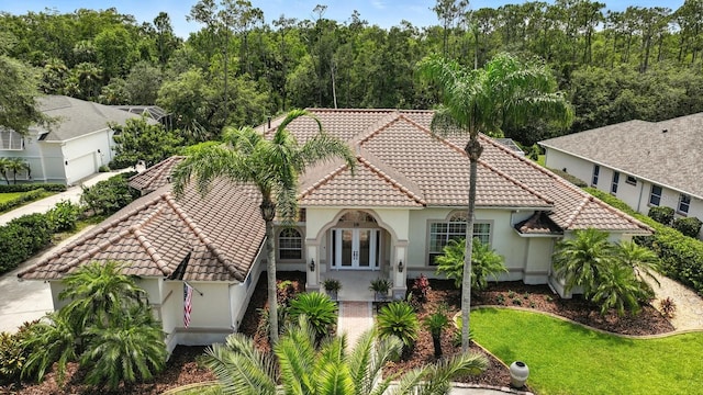 19 Tomoka Cove Way, Ormond Beach, FL 32174 - mediterranean / spanish-style house with a tile roof, stucco siding, french doors, and a front lawn