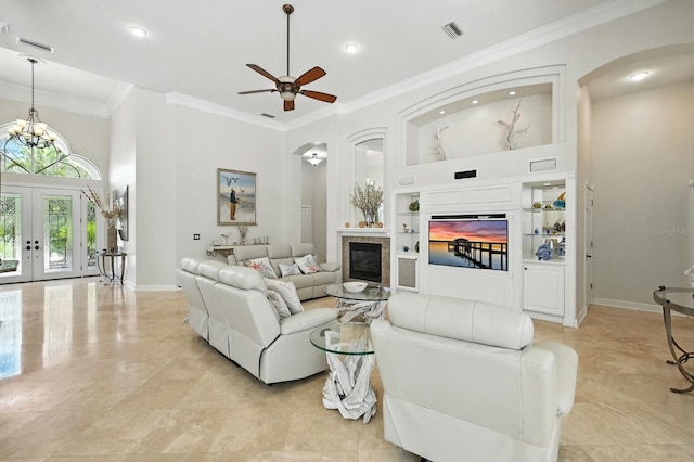 19 Tomoka Cove Way, Ormond Beach, FL 32174 - living area with built in features, arched walkways, a glass covered fireplace, a ceiling fan, and crown molding