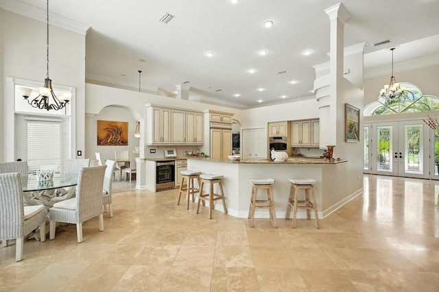 19 Tomoka Cove Way, Ormond Beach, FL 32174 - kitchen featuring cream cabinetry, a chandelier, crown molding, beverage cooler, and recessed lighting
