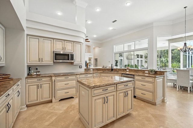 19 Tomoka Cove Way, Ormond Beach, FL 32174 - kitchen with stainless steel microwave, cream cabinets, a peninsula, light stone counters, and ornamental molding