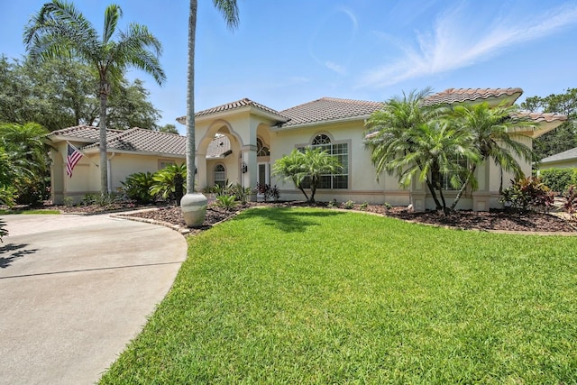 19 Tomoka Cove Way, Ormond Beach, FL 32174 - mediterranean / spanish-style home featuring a tiled roof, stucco siding, and a front lawn