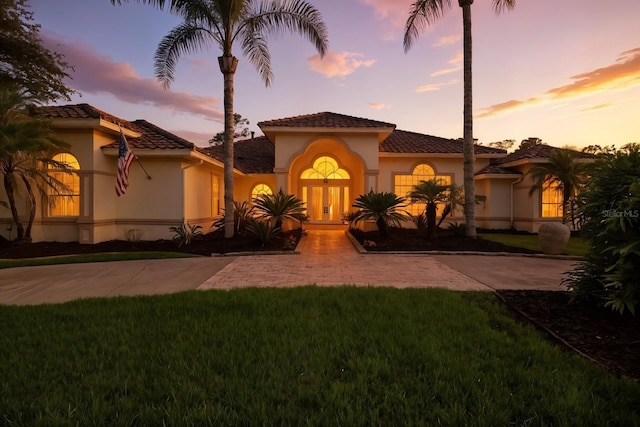 19 Tomoka Cove Way, Ormond Beach, FL 32174 - mediterranean / spanish-style house featuring stucco siding, a front yard, a tile roof, and driveway
