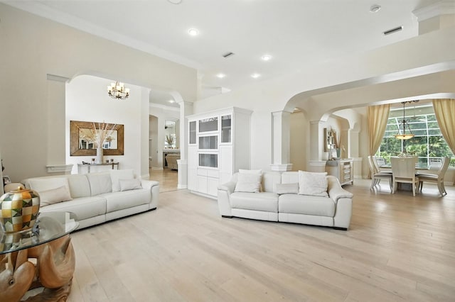 19 Tomoka Cove Way, Ormond Beach, FL 32174 - living room with arched walkways, light wood-style floors, a chandelier, recessed lighting, and crown molding