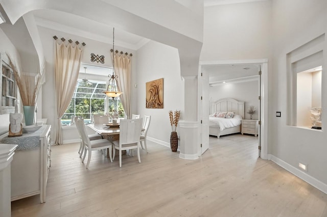 19 Tomoka Cove Way, Ormond Beach, FL 32174 - dining room featuring light wood-style floors, a towering ceiling, and ornamental molding