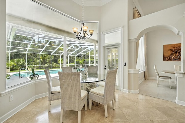 19 Tomoka Cove Way, Ormond Beach, FL 32174 - dining area with plenty of natural light, a sunroom, arched walkways, a chandelier, and a towering ceiling