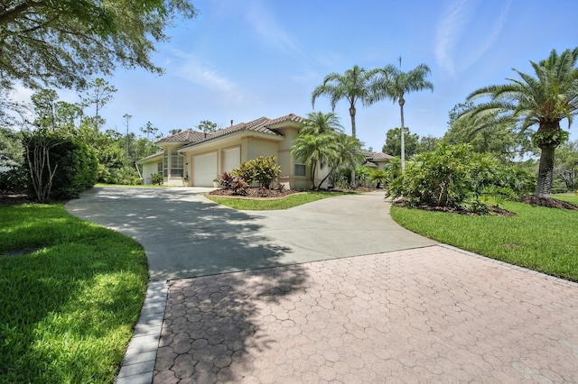 19 Tomoka Cove Way, Ormond Beach, FL 32174 - mediterranean / spanish house with a garage, stucco siding, driveway, a tiled roof, and a front yard