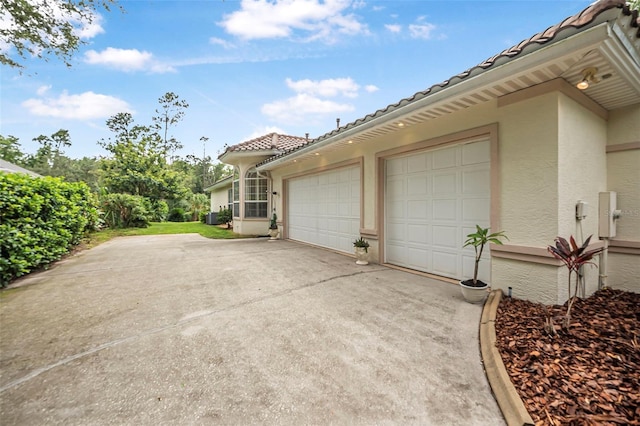19 Tomoka Cove Way, Ormond Beach, FL 32174 - view of home's exterior with concrete driveway, stucco siding, a tile roof, and an attached garage