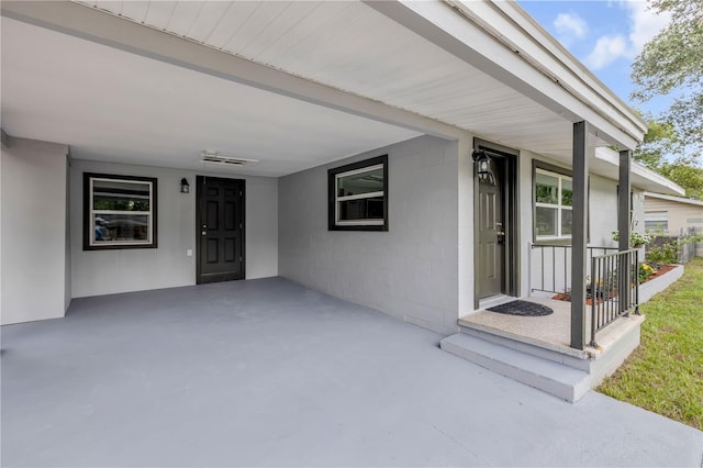173 Cedar Ave, Orange City, FL 32763 - doorway to property featuring concrete block siding, a carport, and covered porch