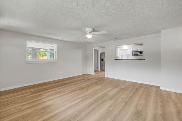 173 Cedar Ave, Orange City, FL 32763 - unfurnished living room featuring a textured ceiling, light wood finished floors, and ceiling fan