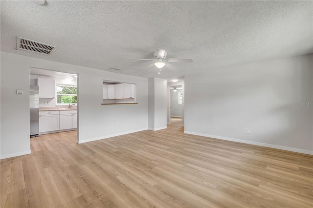 173 Cedar Ave, Orange City, FL 32763 - unfurnished living room with a ceiling fan, a textured ceiling, and light wood-style floors