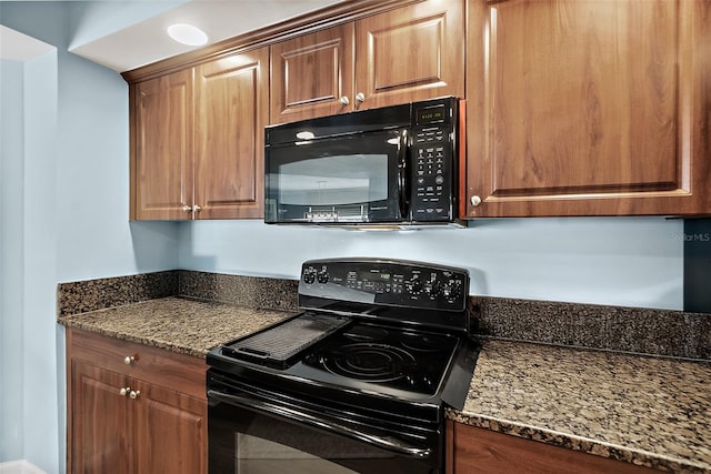 3315 S Atlantic Ave Unit 1605, Daytona Beach Shores, FL 32118 - kitchen featuring black appliances, dark stone countertops, and brown cabinetry